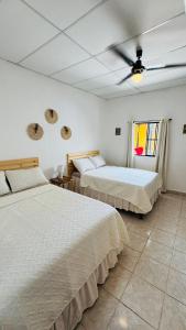ein Schlafzimmer mit zwei Betten und einem Deckenventilator in der Unterkunft Habitación junto a la Catedral de Santa Ana - La Casa de Moris in Santa Ana
