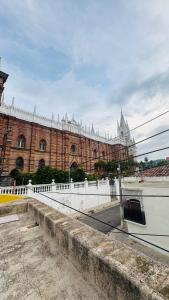 ein großes Gebäude mit einem weißen Zaun davor in der Unterkunft Habitación junto a la Catedral de Santa Ana - La Casa de Moris in Santa Ana