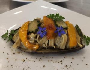 a plate of food with oranges and purple flowers on it at Agriturismo RossoLampone in Gerano
