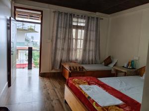 a bedroom with two beds and a large window at Durga Homestay Property of Royal Respite in Pedong