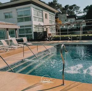 a swimming pool in front of a building at Cumeló Cariló in Carilo