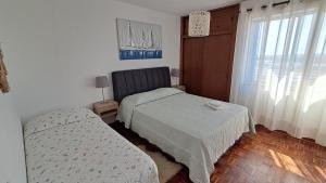 ファロにあるSea View urban apartmentのベッドが2つと窓のある部屋