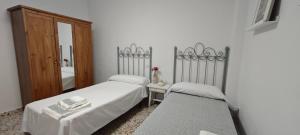 ein Schlafzimmer mit zwei Betten und einem Spiegel in der Unterkunft La Casa de Antonina in Castilblanco de los Arroyos