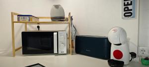eine Mikrowelle und ein Roboter, der neben einem Fernseher steht in der Unterkunft La Casa de Antonina in Castilblanco de los Arroyos
