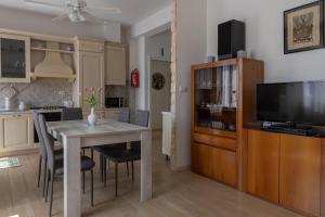 a kitchen and dining room with a table and a television at Le Giare House in Grezzana
