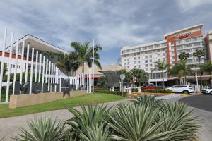 a building with a sign in front of a street at Courtyard by Marriott Panama Multiplaza Mall in Panama City