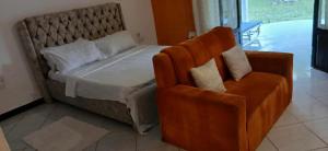 a bedroom with a large bed and a chair at Baby Bird Luxury Studio in Ukunda +4 photos