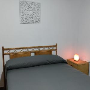 Un dormitorio con una cama y una lámpara en una mesita de noche. en Casa Fortuna, en Mecina Fondales