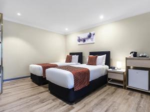 a hotel room with two beds and a tv at BreakFree on Broadway Sydney, an Accor Hotel in Sydney +40 photos