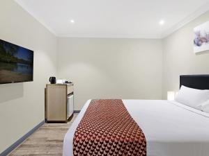 ein Schlafzimmer mit einem Bett und einem Fernseher an der Wand in der Unterkunft BreakFree on Broadway Sydney, an Accor Hotel in Sydney