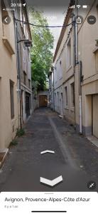 an empty street in an alley between two buildings at À Deux Pas du Palais in Avignon