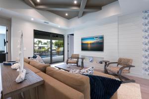 フォート・ローダーデールにあるNew Villa Near Hardrock Fll Wboating Near Beachのリビングルーム(大きなソファ、椅子付)