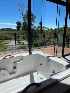 Una bañera blanca frente a una ventana. en Chalé Recanto Santos, en Boa Vista