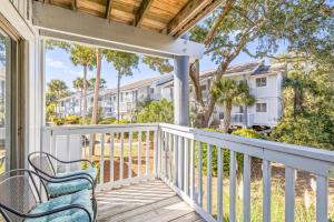 eine Veranda mit einer Bank und Blick auf Eigentumswohnungen in der Unterkunft Lagoon Villa 19 - Lagoon Lifestyle! Center of Wild Dunes! in Isle of Palms