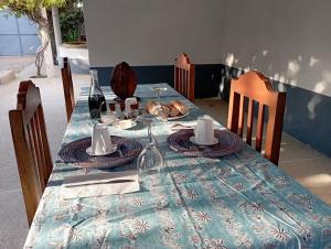 a table with a blue table cloth and wine glasses at Guorgui's bed in Ndangane