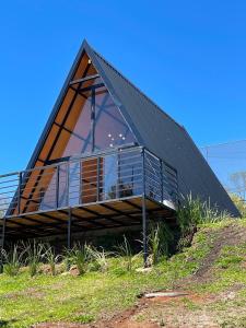 una casa con un techo triangular en una colina en Chalé Recanto Santos, en Boa Vista 32 fotos más
