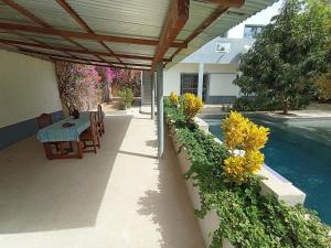 a patio with a table and chairs and flowers at Guorgui's bed in Ndangane