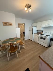 a kitchen with a table and a kitchen with white appliances at Airport Manor Unit 2, 2 Bedroom Apartment in Torbay