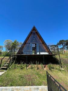 Una pequeña casa con techo de cristal en un campo. en Chalé Recanto Santos, en Boa Vista