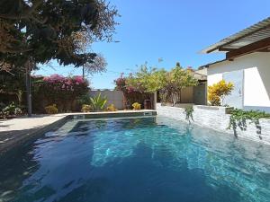 a swimming pool in a house with blue water at Guorgui's bed in Ndangane +6 photos
