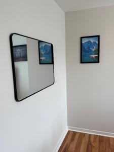 a mirror in a white room with two pictures on a wall at Airport Manor Unit 2, 2 Bedroom Apartment in Torbay +6 photos