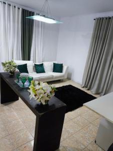 a living room with a couch and a table with flowers at Casa aconchego in Sao Paulo