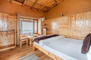 a bedroom with a bed and a desk and a window at Stonewood Homestay in Jageshwar