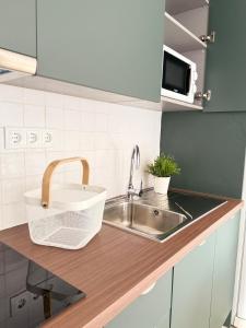 eine Küchentheke mit Spüle und Mikrowelle in der Unterkunft Casinha d'Adélia in Aljezur