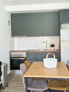 eine Küche mit einem Holztisch mit Stühlen und einem Waschbecken in der Unterkunft Casinha d'Adélia in Aljezur