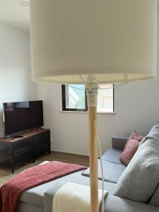 ein Wohnzimmer mit einer Couch und einer Lampe in der Unterkunft Casinha d'Adélia in Aljezur