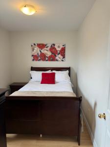a bedroom with a bed with a red pillow on it at Airport Manor Unit 3, 2 Bedroom Apartment in Torbay