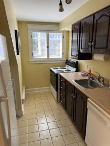 a kitchen with a sink and a stove at Midstream Manor Unit 2, 2 Bedroom Apartment in St. John's +8 photos