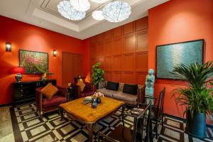 a living room with orange walls and a table at Amber Bay Hotel & Suites Da Nang in Danang