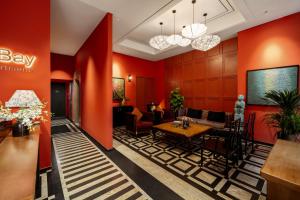 a lobby with red walls and a table and chairs at Amber Bay Hotel & Suites Da Nang in Da Nang