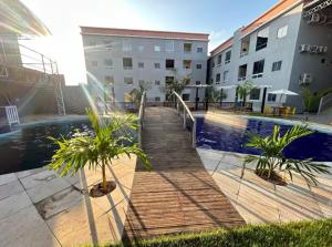 a boardwalk leading to a swimming pool in a building at Ilha Bela Alter do chão - Apartment 2 suites in Santarém +2 photos