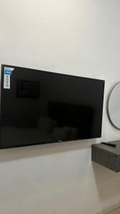 Un televisor de pantalla plana colgado en una pared en ارجان نجد للوحدات المخدومه, en Al Nairyah