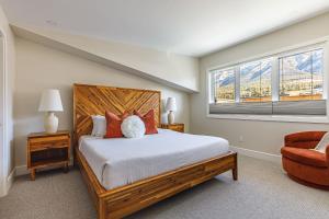 a bedroom with a large bed and a window at Aurora Luxe - Stunning Townhouse Private Hot Tub in Canmore