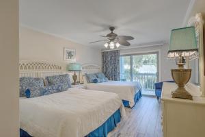 ein Schlafzimmer mit zwei Betten und einem Fenster in der Unterkunft Lagoon Villa 9 - Superb Villa by Pool! Short Walk to Beach in Isle of Palms + 21 Fotos