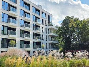 a tall white apartment building with windows at Apartament Mono Ełk CENTRUM in Ełk