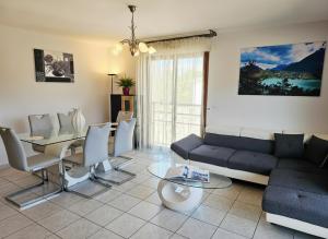 a living room with a couch and a table at Au cœur de St Jorioz, spacieux appartement avec terrasse et vue montagne. in Saint-Jorioz