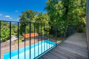 a balcony with a swimming pool and a wooden deck at Moinhos do Coto in Vila Verde +12 photos
