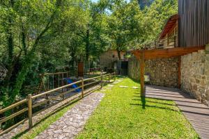 a wooden walkway next to a building with a fence at Moinhos do Coto in Vila Verde