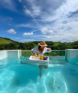 a man in a hat in a toy boat in a swimming pool at Cupulesantorini in Santa Isabel