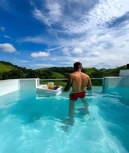 a man is standing in a swimming pool at Cupulesantorini in Santa Isabel +56 photos