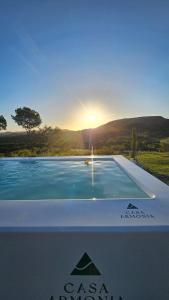 una piscina con il tramonto sullo sfondo di NEW! Casa de campo con diseño - Casa Armonia Uruguay a Aiguá