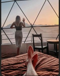 a woman standing on a bed in front of a window at Rum Monet in Disah