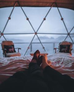 a person laying on a bed with their feet up at Rum Monet in Disah