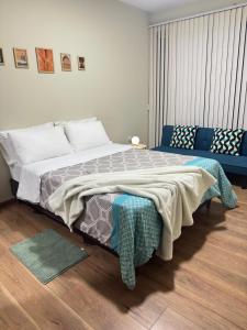 una camera da letto con un letto grande e un divano di Garzonier exclusivo zona La Recoleta a Cochabamba