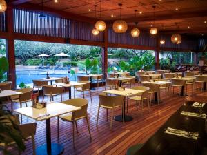 ein Restaurant mit Tischen und Stühlen und einem Pool in der Unterkunft Holiday Inn & Suites Port Moresby by IHG in Port Moresby