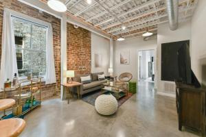a living room with a couch and a tv at Warehouse District Intimate One Bedroom in New Orleans
